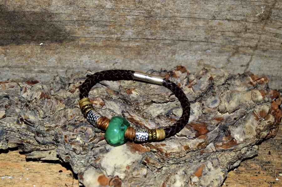 pulsera turquesa sobre corteza de arbol